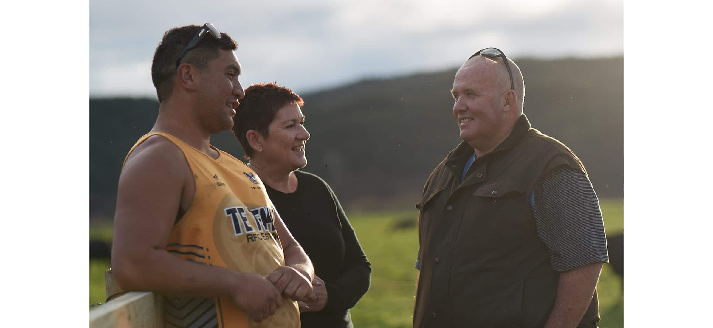 Farm manager, Hare, and owner, Di, leaning against a fence and talking to co-owner, Colin.